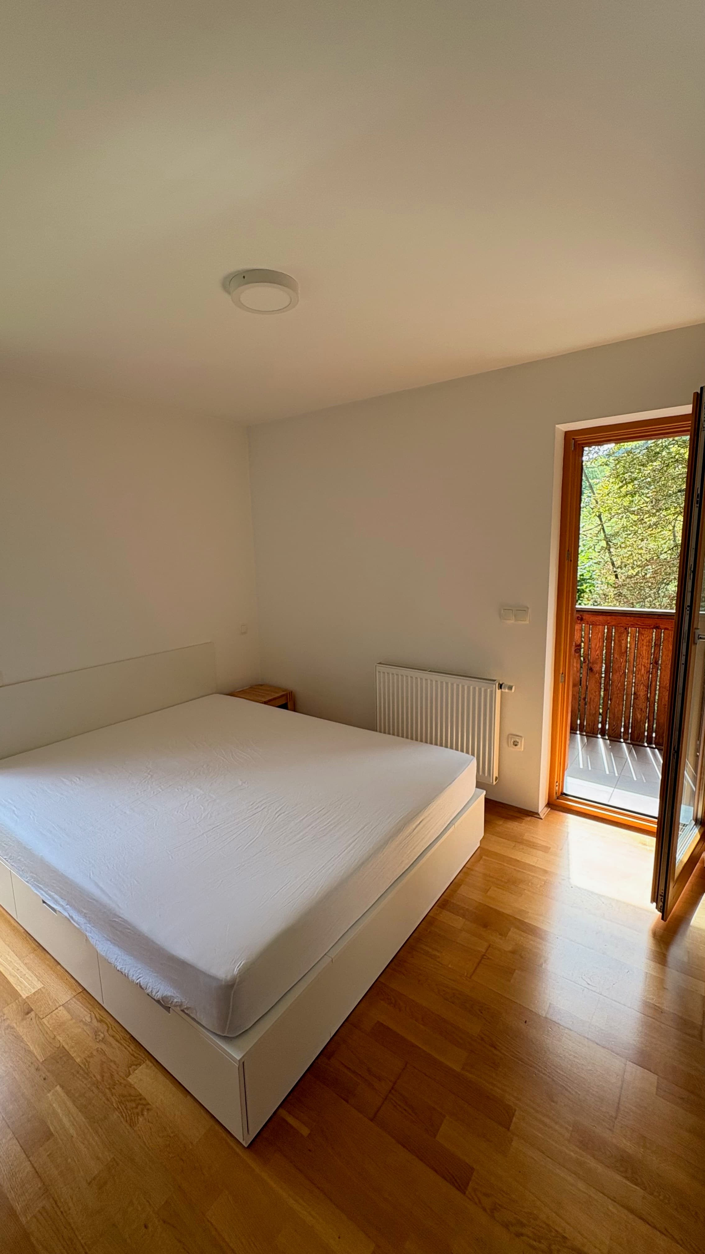 Spalnica z balkonskimi vrati in pogledom na gozd, apartma Mojstrana